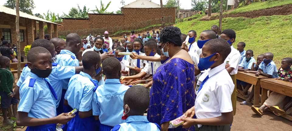 Umuyobozi w'ishuri Ikibondo hamwe n'abana bazanye, mu gushyikiriza impano bagenzi babo, batanga amakaye