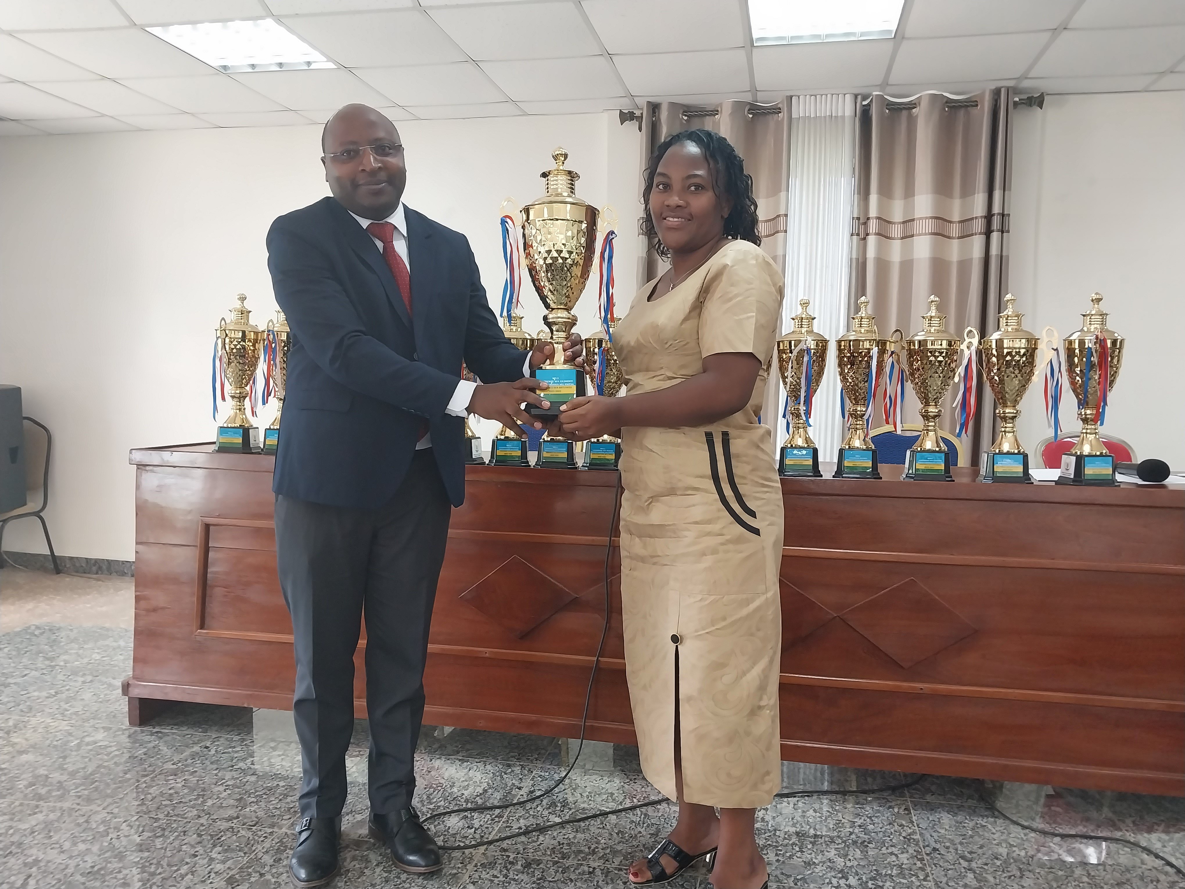 Umuyobozi w'akarere ka Gakenke Nizeyimana JMV ashyikiriza Umwe mu bagitifu b'imirenge igikombe