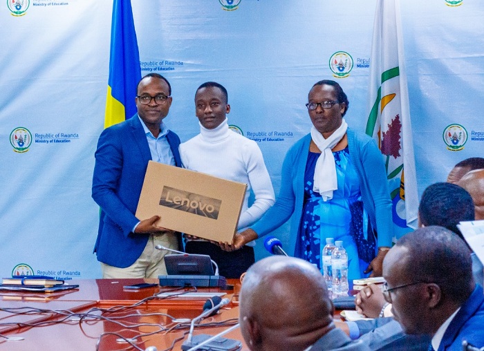 Umunyamabanga wa Leta muri MINEDUC, Twagirayezu Gaspard, ahemba umunyeshuri wahize abandi mu cyiciro rusange cy'amashuri yisumbuye