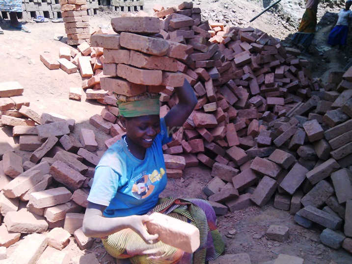 Umwe mu bagore ukora akazi ko gutwara amatafari kwa Gloriose.