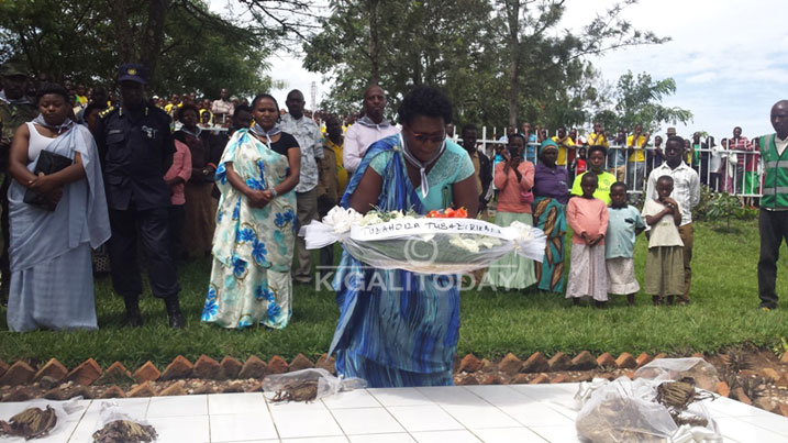 Uwimana Xaverine ashyira indabo ahashyinguye imibiri y'Abatutsi bazize Jenoside.