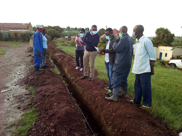 Aha abakozi barimo bareba imiterere y'agace kari gushyirwamo amatiyo ayobora amazi mu ngo z'Abaturage