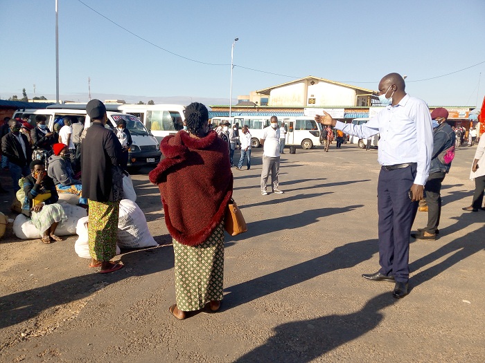 Aha Vice Mayor Kayiranga (wambaye ishati y'umweru) yabwiraga abaturage ko batagomba kwegerana mu gihe bategereje imodoka