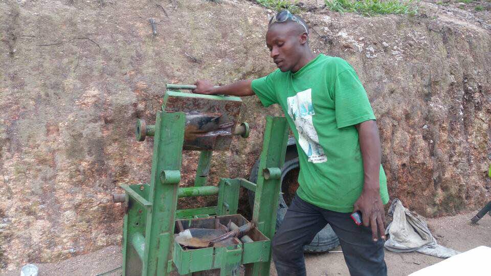 Muhayimana ahagaze imbere ya kimwe mu byuma bisya imyumbati akora