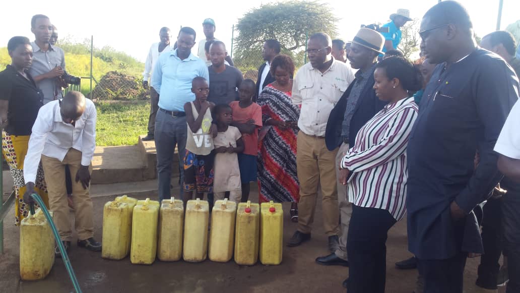 Samba Bathily (wambaye imyenda y'umukara), umuyobozi wa Solektra akaba n'umwe mu bayishinze yerekwa uko abaturage batangiye kugerwaho n'amazi meza