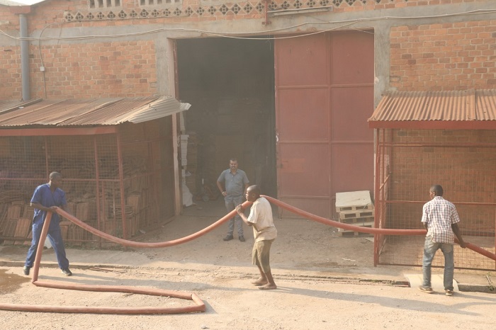 Bamwe mu bakozi b'uruganda bafatanyaga na polisi mu kuzimya umuriro