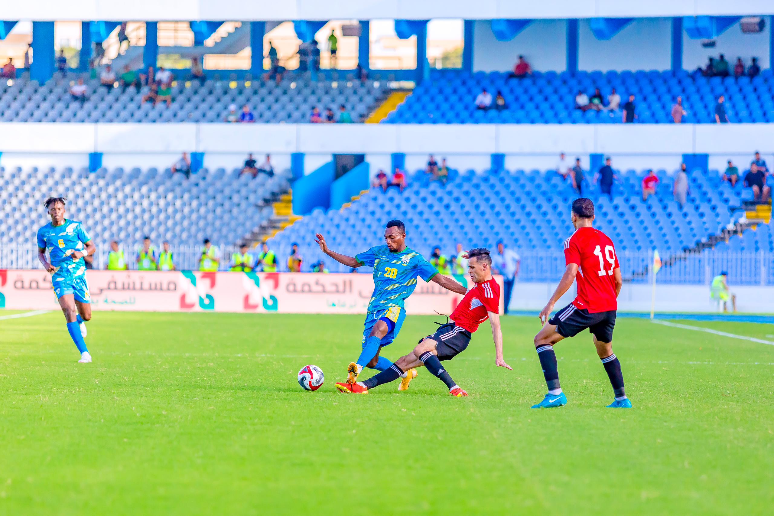 Niyomugabo Claude agerageza kwaka umupira abakinnyi ba Libya